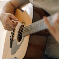 Man plays an acoustic guitar in a room at home. Hobby a musician. life at home